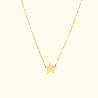 Gold star pendant necklace on a delicate chain.