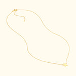 Delicate gold necklace with a star pendant hanging at the center.