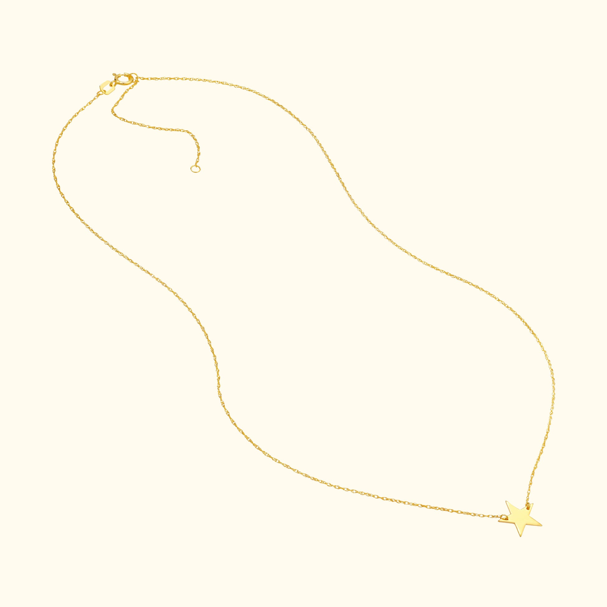 Delicate gold necklace with a star pendant hanging at the center.