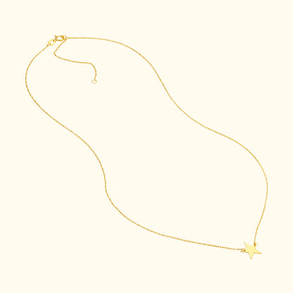 Delicate gold necklace with a star pendant hanging at the center.