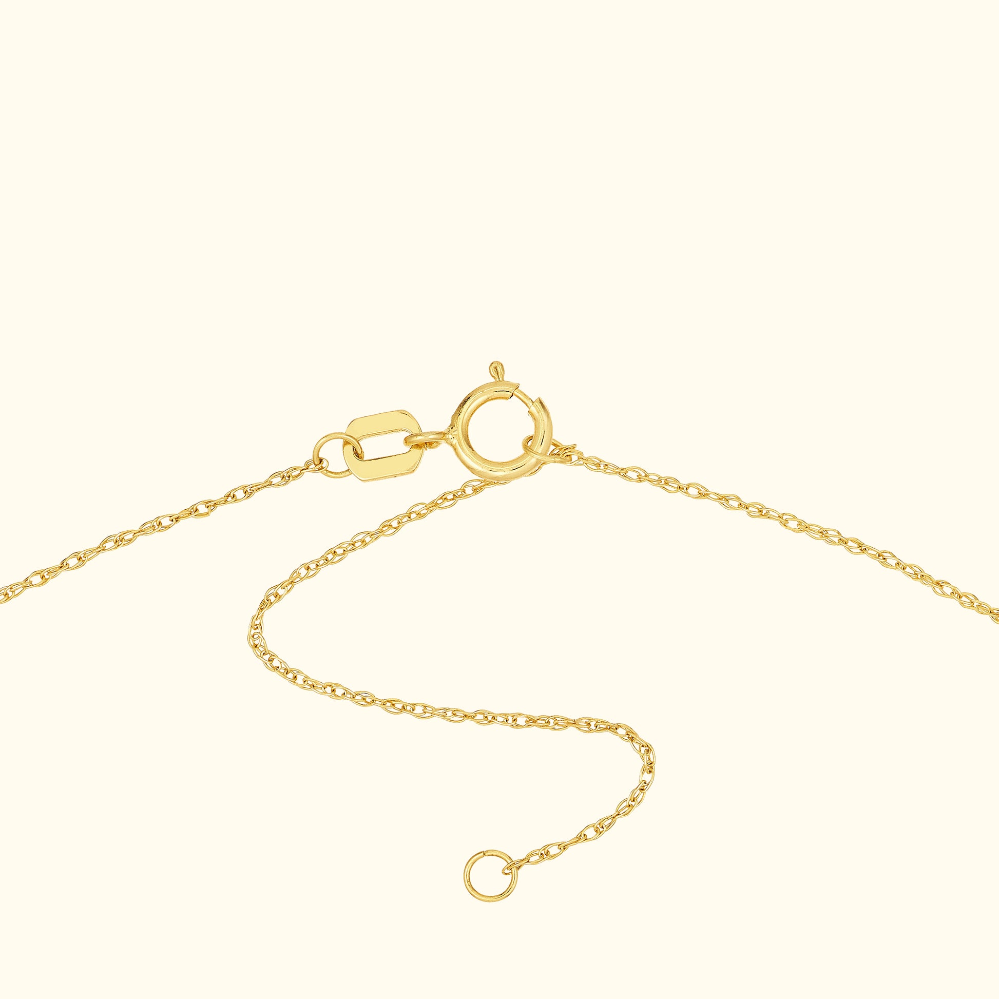 Close-up of a delicate gold chain with a clasp and adjustable length.