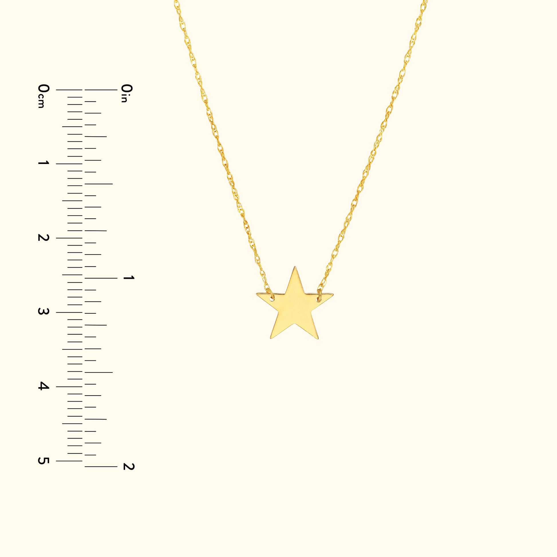 Gold star pendant necklace on a delicate chain with measurement scale.