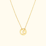 Gold necklace featuring a circular pendant with a moon and star design.