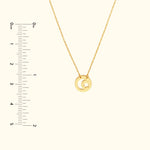 Gold necklace featuring a crescent moon and star pendant against a neutral background.