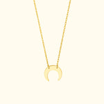 Gold crescent moon pendant necklace on a delicate chain.