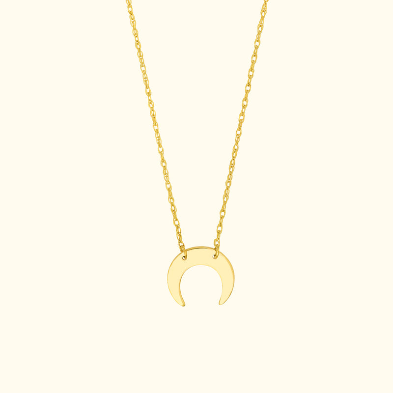 Gold crescent moon pendant necklace on a delicate chain.