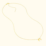 Delicate gold necklace featuring a crescent moon pendant.