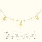 Gold star pendant necklace featuring three star charms on a delicate chain.