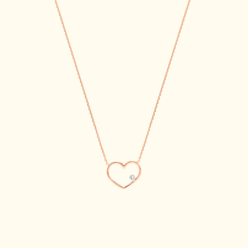 Rose gold heart necklace with a small diamond accent.