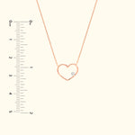 Rose gold heart necklace with a small diamond detail, displayed on a light background.