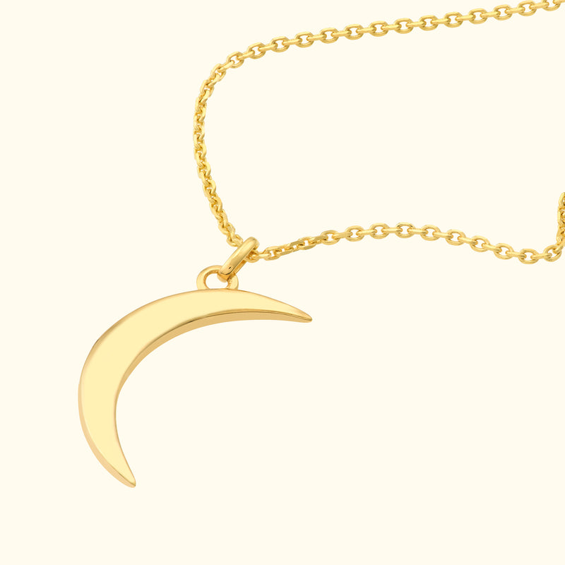 Gold crescent moon pendant on a delicate chain necklace.