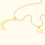 Gold necklace featuring a crescent moon and star pendant on a delicate chain.