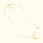 Gold necklace featuring a crescent moon and star pendant on a delicate chain.