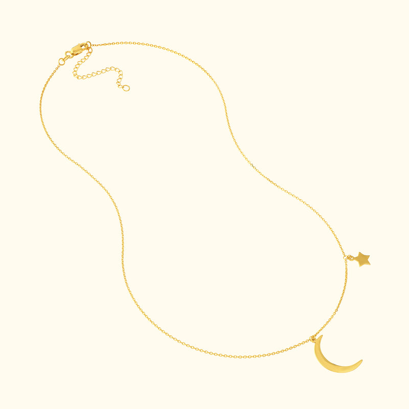 Gold necklace featuring a crescent moon and star pendant on a delicate chain.