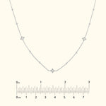 Delicate silver necklace with diamond accents set in a curved design.