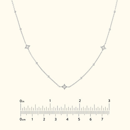 Delicate silver necklace with diamond accents set in a curved design.