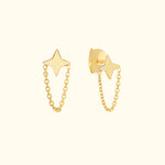 Gold star earrings with chain detail hanging from star-shaped studs.