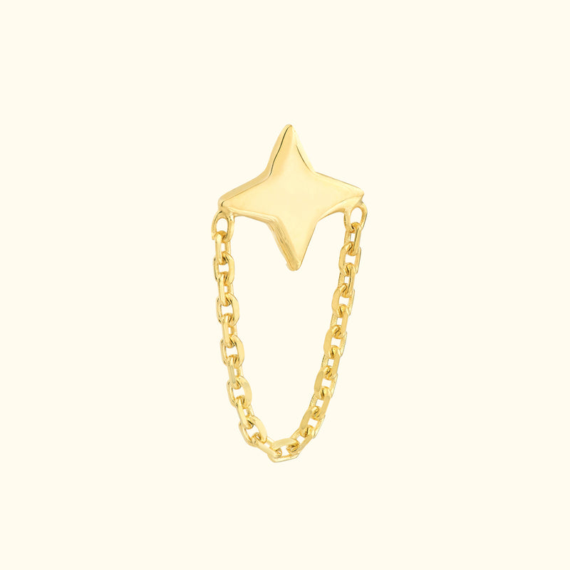 Gold star-shaped ring connected by a delicate chain.