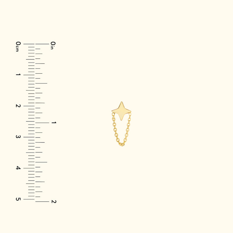 Gold star-shaped charm connected by a delicate chain, displayed with a ruler for size reference.
