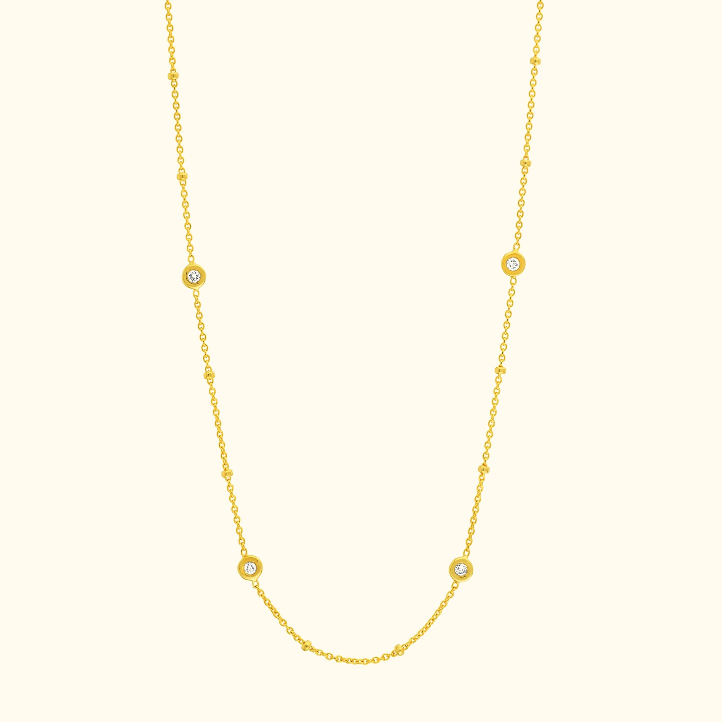 Delicate yellow gold necklace with circular gemstone accents.