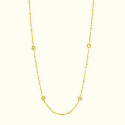 Delicate yellow gold necklace with circular gemstone accents.