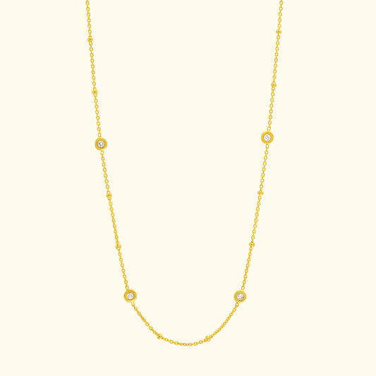 Delicate yellow gold necklace with circular gemstone accents.