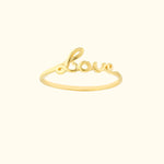 Gold ring with the word "Love" elegantly designed in a cursive font.