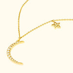 Gold necklace featuring a crescent moon and a star, adorned with sparkling gems.