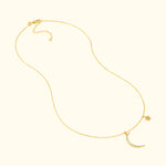Delicate gold necklace featuring a crescent moon and star charm with sparkling accents.