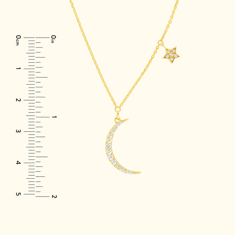Gold necklace featuring a crescent moon and star, adorned with sparkling gems.