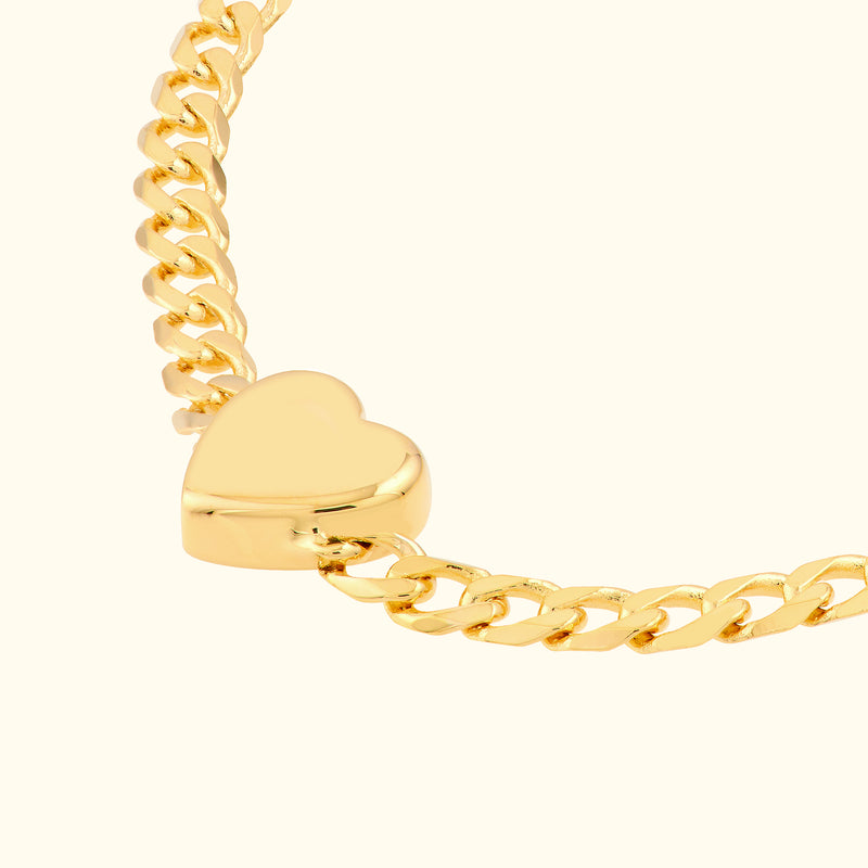 Gold chain bracelet featuring a heart-shaped clasp.