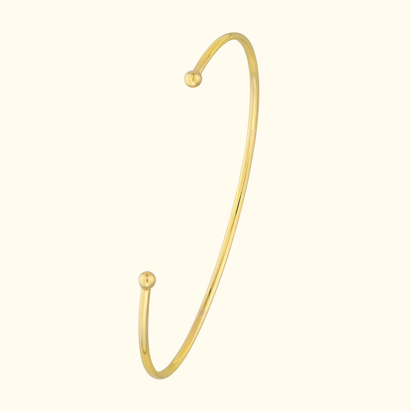 Simple gold cuff bracelet with rounded ends, elegantly minimalistic design.