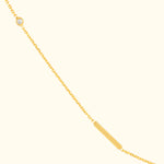 Delicate gold necklace featuring a bar pendant and a small diamond charm.