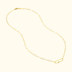 Delicate gold chain necklace with a central oval link and a small round bead.