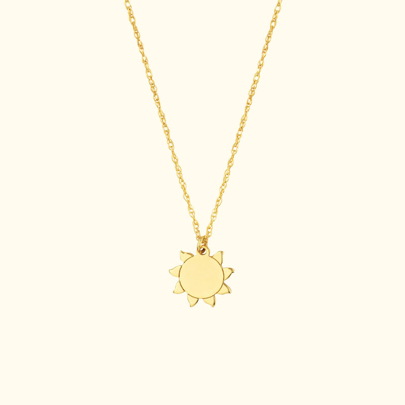 Delicate gold necklace featuring a sun-shaped pendant on a fine chain.