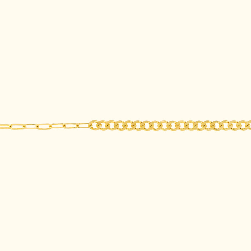 Thin gold chain necklace with alternating link styles on a light background.