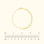 Delicate gold bracelet featuring a mixed link design, displayed on a light background.