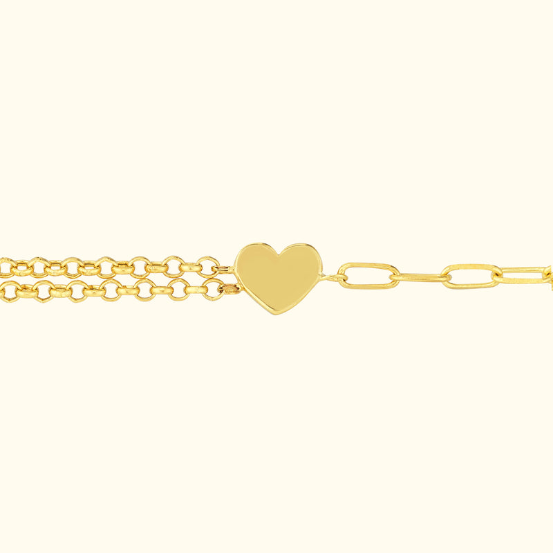 Golden bracelet with a heart-shaped pendant and two chain links.