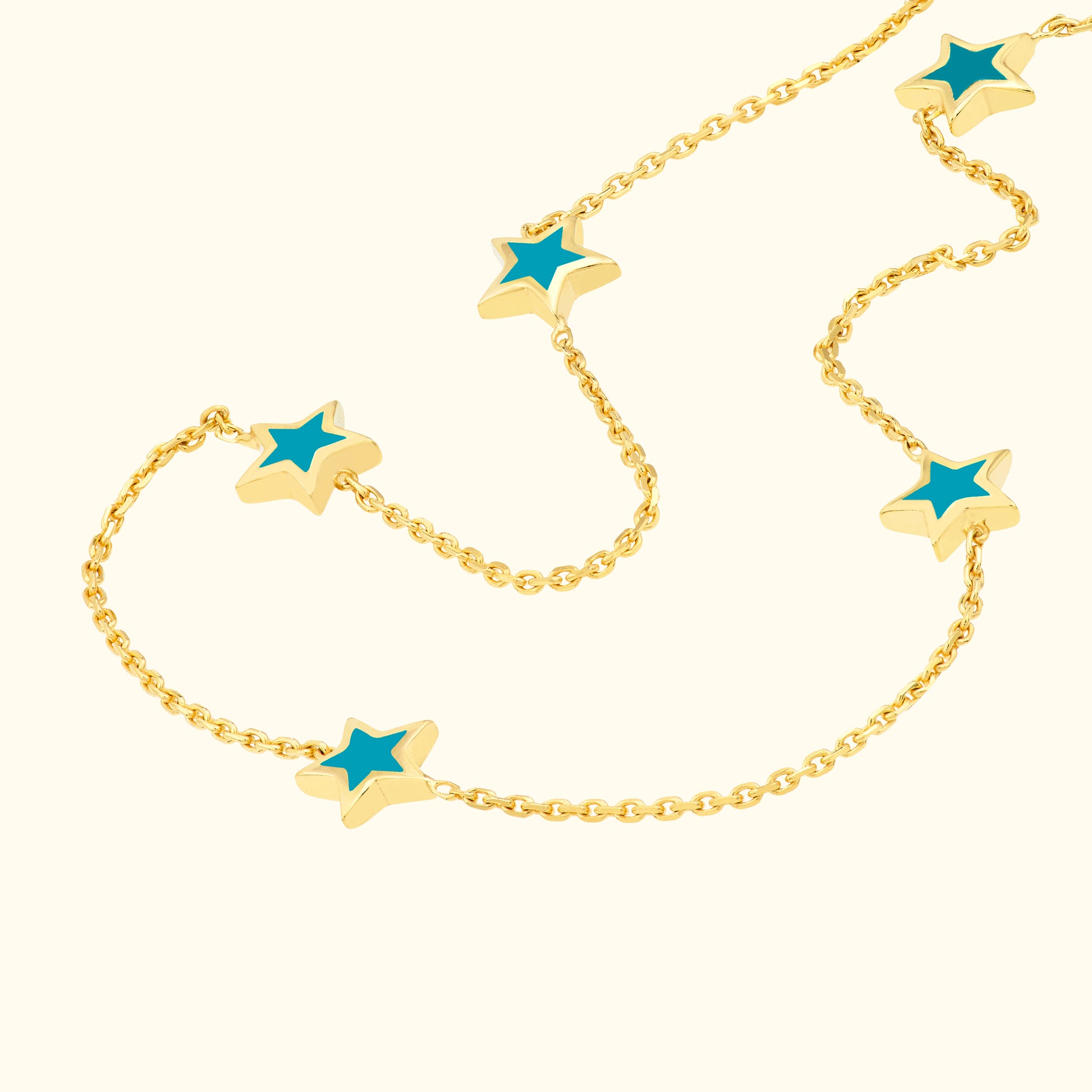 Gold chain necklace featuring alternating star-shaped charms with turquoise centers.