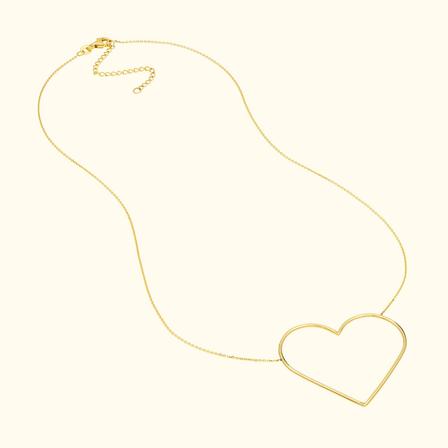 Gold necklace with a large, open heart pendant.