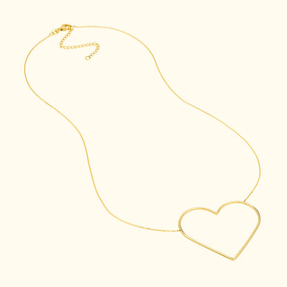 Gold necklace with a large, open heart pendant.