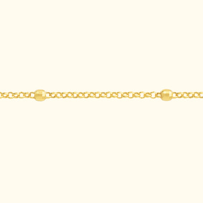 Delicate gold chain bracelet with round beads interspersed along the links.