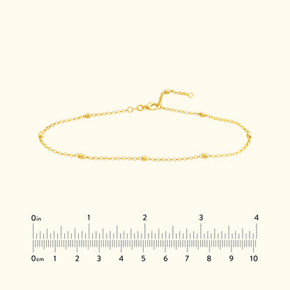 Delicate gold bracelet with small links and a clasp, displayed on a neutral background.