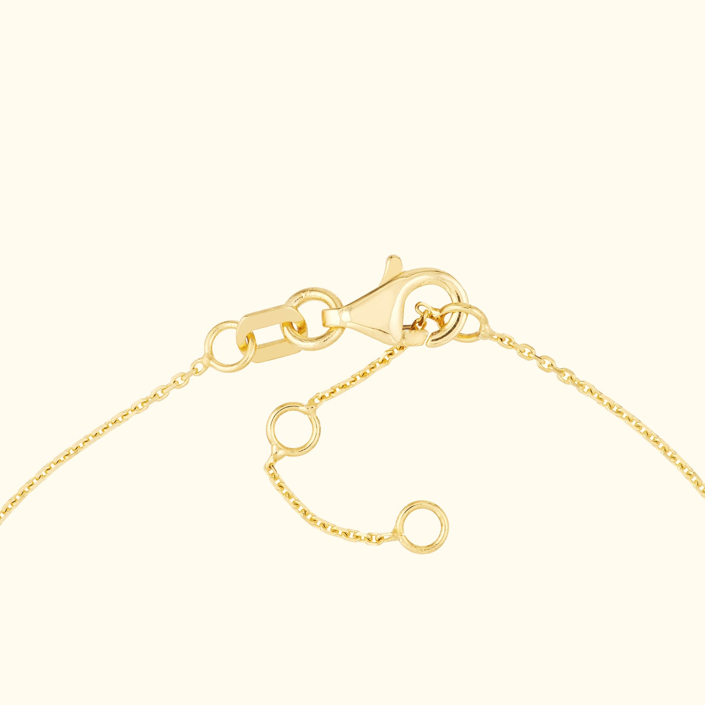 Close-up of a gold chain bracelet with a lobster clasp and adjustable links.