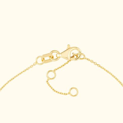 Close-up of a gold chain bracelet with a lobster clasp and adjustable links.