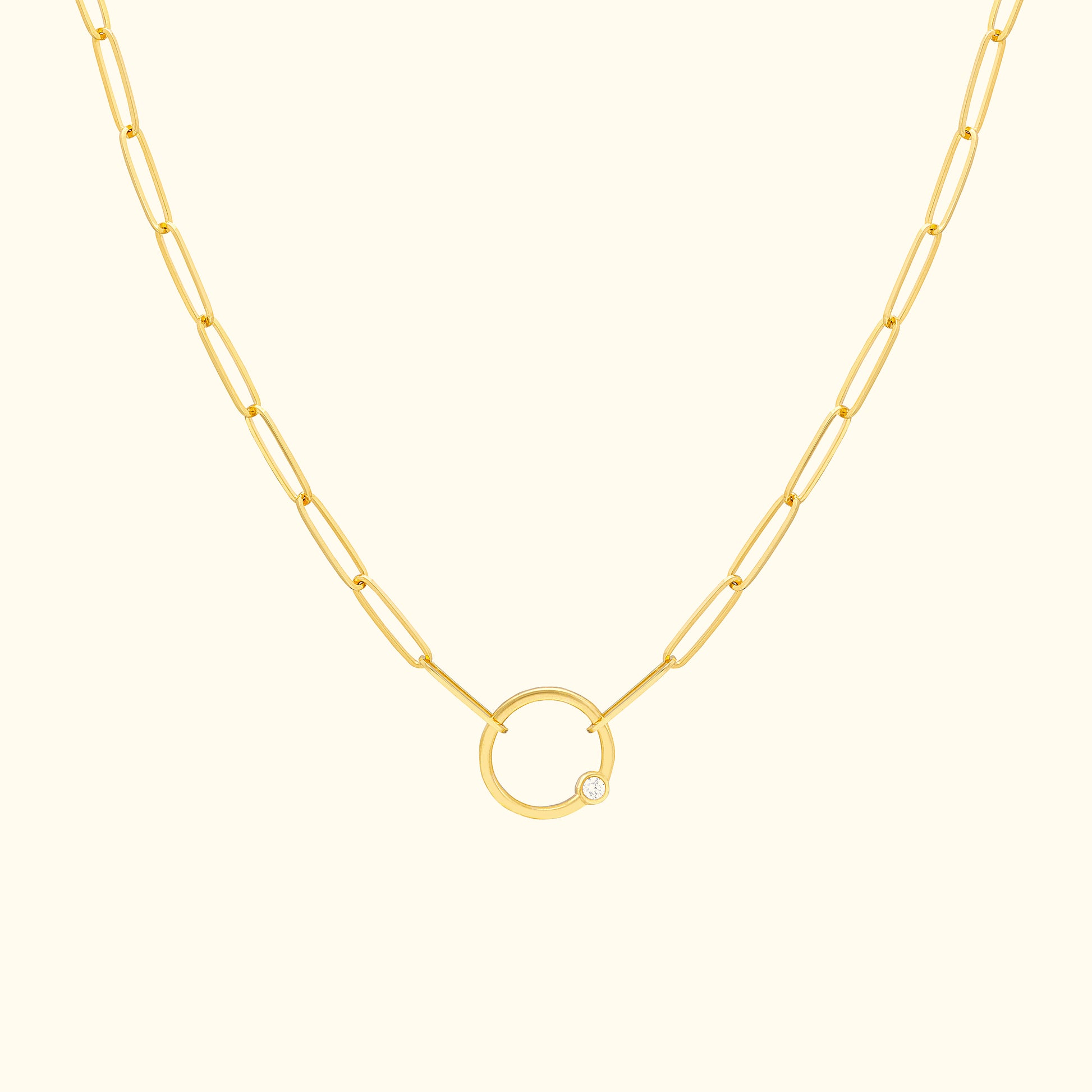 Gold chain necklace featuring a circular pendant with a small diamond.