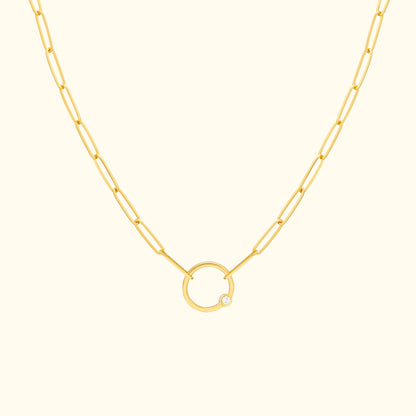 Gold chain necklace featuring a circular pendant with a small diamond.