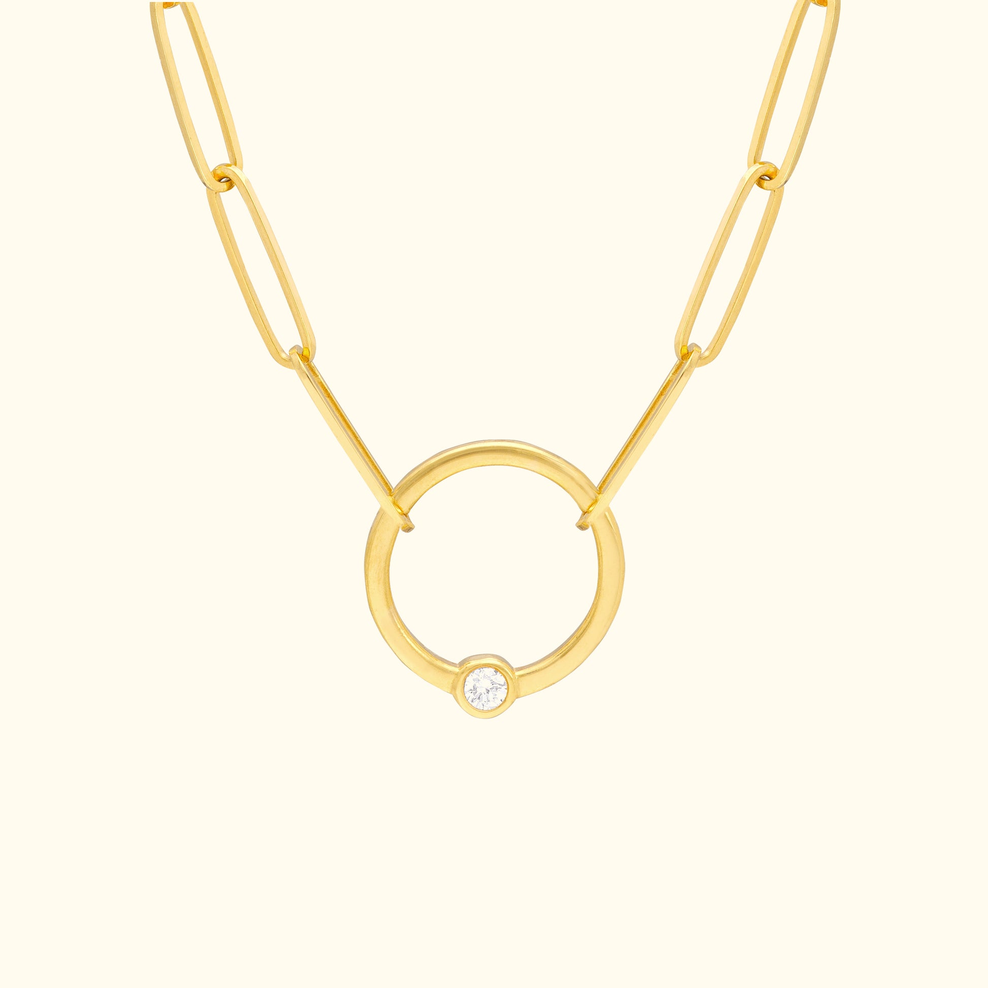 Gold chain necklace featuring a circular pendant with a small diamond.