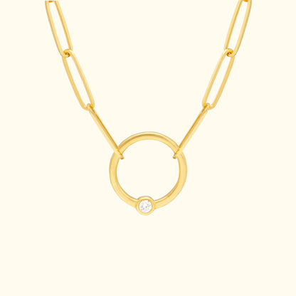 Gold chain necklace featuring a circular pendant with a small diamond.