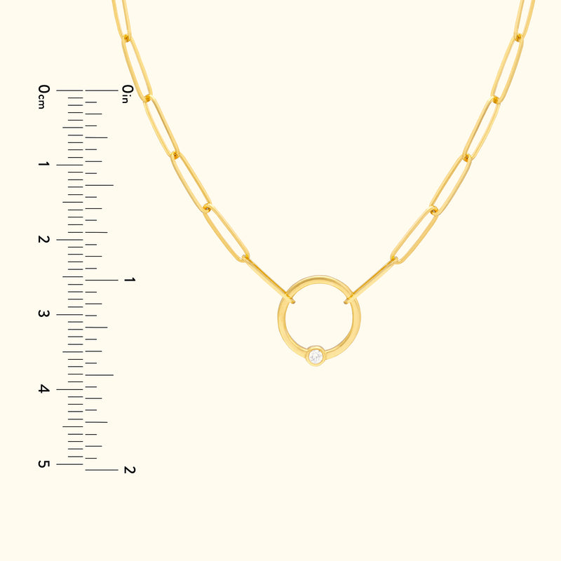 Gold chain necklace featuring a circular pendant with a small diamond.